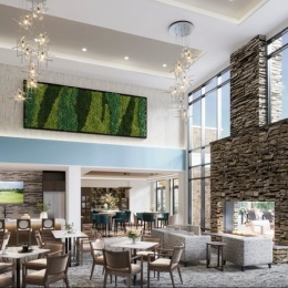 Resident lounge at Chorus at Asheville senior living apartments in Asheville, featuring cushioned chairs and coffee tables.