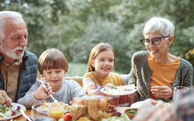 a family eats around an outdoor table