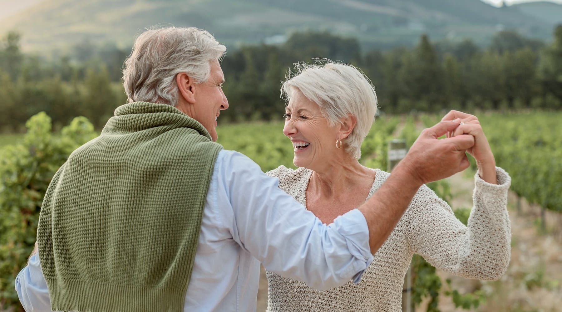 Two residents smiling and dancing at Chorus at Asheville senior living apartments in Asheville, featuring natural lighting.